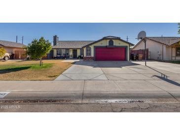 Cute single story home with a red garage door and well-maintained lawn at 7945 W Wethersfield Rd, Peoria, AZ 85381