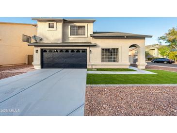 Two-story house with a black garage door and landscaped front yard at 9920 W Calle Encorvada --, Phoenix, AZ 85037