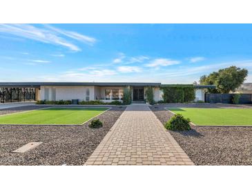 Single story home with landscaped lawn and walkway at 4901 W Soft Wind Dr, Glendale, AZ 85310