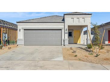 Charming single-story home with desert landscaping, a two-car garage, and a bright yellow front door at 5162 E Umber Rd, San Tan Valley, AZ 85143