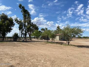 Aerial view of a single story home on acreage with a large yard and mature trees at 51989 W Esch Trl, Maricopa, AZ 85139