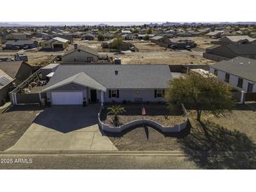 Single story home with landscaped front yard, large driveway and RV parking at 8547 W Magnum Dr, Arizona City, AZ 85123