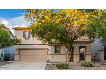 Two-story house with tan exterior, landscaped yard, and two-car garage at 1174 E Canyon Creek Dr, Gilbert, AZ 85295