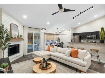 Open living area with a cozy sectional sofa, fireplace, and access to the pool at 15201 N 61St Ave, Glendale, AZ 85306