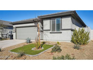 Single-story home with gray exterior, two-car garage, and landscaped front yard at 17852 W Country Club Ter, Surprise, AZ 85387