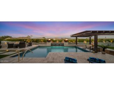 Stunning backyard with a sparkling pool, pergola, and fire features at 28219 N Needle Rock Ct, Rio Verde, AZ 85263