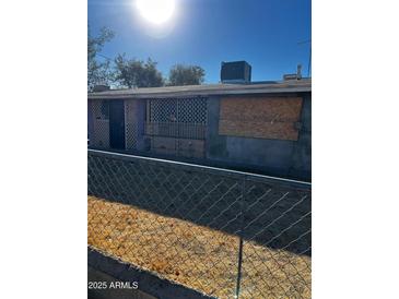 Ranch style home with a chain link fence and needs some TLC at 299 N Fresno St, Chandler, AZ 85225