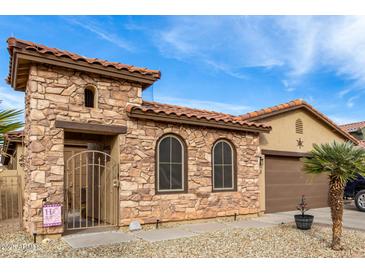 Beautiful stone and stucco exterior boasts a charming design and welcoming curb appeal at 36248 W Cartegna Ln, Maricopa, AZ 85138