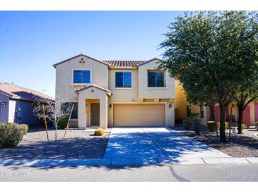 Two-story house with tan exterior, two-car garage, and landscaping at 36285 N Mirandesa Dr, San Tan Valley, AZ 85143