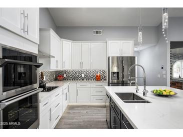 Modern kitchen with stainless steel appliances and white cabinetry at 6102 E Nisbet Rd, Scottsdale, AZ 85254