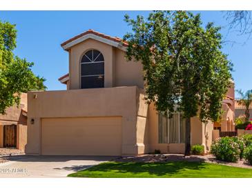 Two-story house with tan exterior, attached garage, and landscaped lawn at 6439 E Redmont Dr, Mesa, AZ 85215