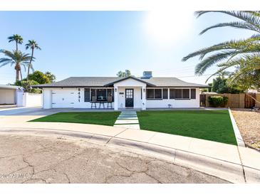 Charming mid-century home features a manicured lawn and updated facade at 8431 E Stella Ln, Scottsdale, AZ 85250