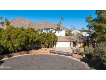 Aerial view of single story home with a large yard, mountain views, and mature trees at 5616 E Argyle Dr, Phoenix, AZ 85018