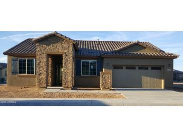 Inviting single-story home featuring a stone facade, shutters, and a two-car garage at 17990 W Fairview St, Goodyear, AZ 85338