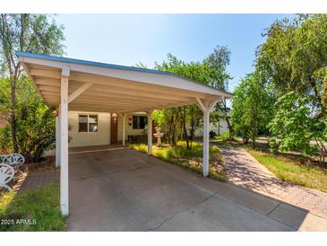 Brick walkway leads to charming ranch home with carport and established landscaping at 2825 N 33Rd Pl, Phoenix, AZ 85008