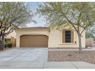 Tan house with brown garage door, landscaping, and driveway at 29798 N 121St Dr, Peoria, AZ 85383