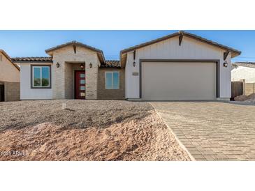 New construction home with brick and white exterior, two-car garage, and paver driveway at 6208 S Eagle Pass Rd, Gold Canyon, AZ 85118