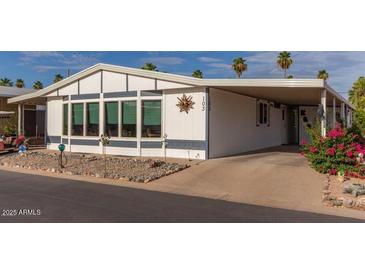 Single-wide manufactured home with carport and landscaping at 9302 E Broadway Rd # 103, Mesa, AZ 85208