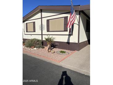 Mobile home exterior with landscaped yard and American flag at 11596 W Sierra Dawn Blvd # 278, Surprise, AZ 85378