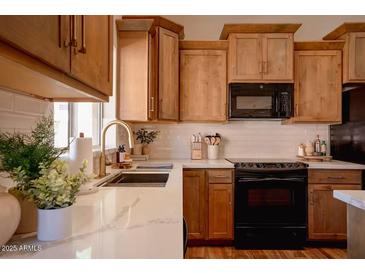 Modern kitchen with wood cabinets, quartz countertops, and stainless steel appliances at 2920 E Fox St, Mesa, AZ 85213