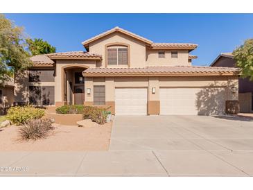 Two-story house with a three-car garage and desert landscaping at 6216 W Morrow Dr, Glendale, AZ 85308