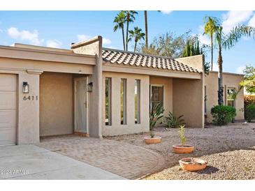 Inviting single-story home featuring desert landscaping and a charming tile roof and private front entry at 6411 E Presidio Rd, Scottsdale, AZ 85254