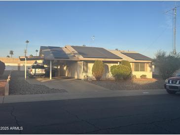 Ranch-style home with solar panels and carport at 12229 N Mission Dr, Sun City, AZ 85351