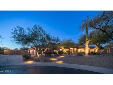 Beautiful desert home with landscaped yard, large driveway, and three-car garage at 12824 E Jenan Dr, Scottsdale, AZ 85259