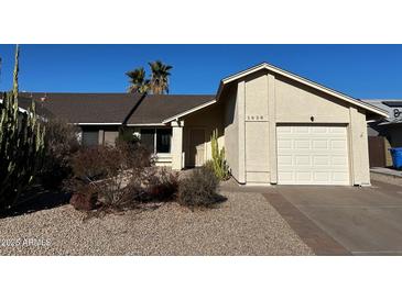 Front exterior view of a single story home with a two car garage and desert landscaping at 1638 E Sandra Ter, Phoenix, AZ 85022