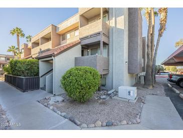 Exterior view of condo building, showing landscaping and parking at 1645 W Baseline Rd # 2075, Mesa, AZ 85202