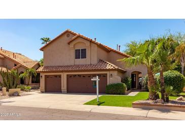 Two-story house with brown double garage doors and a landscaped lawn at 16636 S 34Th Way, Phoenix, AZ 85048