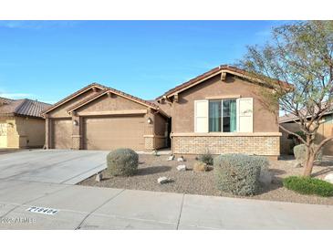 Tan two-story house with a three-car garage and landscaping at 18404 W Long Lake Rd, Goodyear, AZ 85338