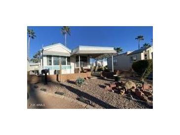 Mobile home exterior with covered porch and landscaped yard at 2271 S Seminole Dr, Apache Junction, AZ 85119