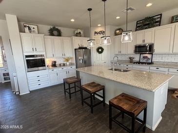 Spacious kitchen featuring granite countertops, white cabinets, and an island at 22917 E Camina Buena Vis, Queen Creek, AZ 85142