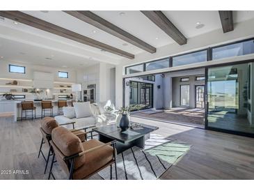 Bright living room with wood floors, beamed ceilings, large sliding glass doors and modern furnishings at 24642 N 123Rd Pl, Scottsdale, AZ 85255