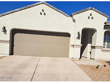 Two-story home with neutral stucco exterior, two-car garage, and desert landscaping at 40130 W Sunland Dr, Maricopa, AZ 85138