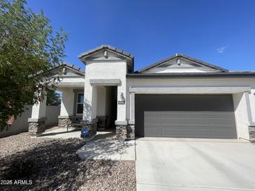 Single-story home with a two-car garage and desert landscaping at 4744 W Orange Ave, Coolidge, AZ 85128