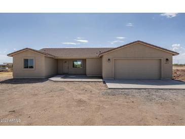 New single-story home with attached two-car garage and desert landscaping at 24604 W Duane Ln, Wittmann, AZ 85361
