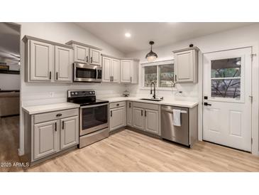 Modern kitchen featuring stainless steel appliances and light cabinets at 5715 N 105Th Ln, Glendale, AZ 85307