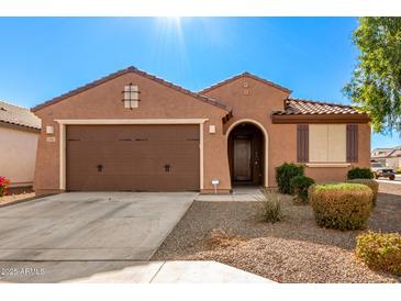 One-story home with brown exterior, two-car garage, and landscaped front yard at 25969 W Tina Ln, Buckeye, AZ 85396