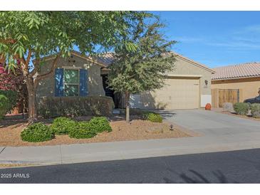 House exterior with tan walls, blue shutters, and a two-car garage at 27194 N Skipping Rock Rd, Peoria, AZ 85383