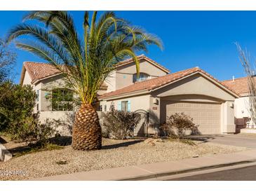 Two-story house with tan exterior, tile roof, and a palm tree in the front yard at 3818 N Lomond Cir, Mesa, AZ 85215