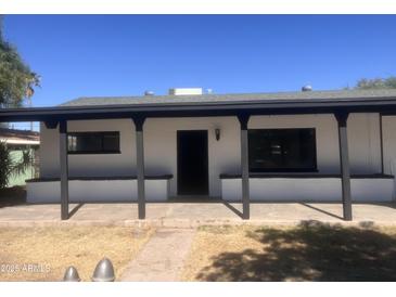 White house with a covered porch and a well-maintained lawn at 404 W 13Th St, Eloy, AZ 85131