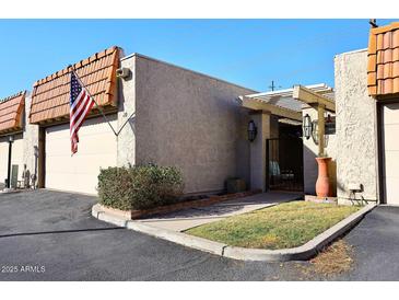 Front view of a charming home with a pergola and American flag at 5100 N Miller Rd # 20, Scottsdale, AZ 85250