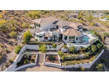 Expansive desert home featuring a tile roof, pool, landscaping, and outdoor seating areas at 5655 N Camelback Canyon Dr, Phoenix, AZ 85018