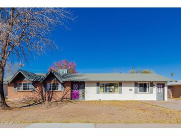 Ranch style home with brick and white exterior, purple door and mature trees at 936 E 8Th Pl, Mesa, AZ 85203