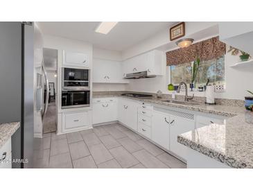 Modern kitchen with white cabinets, granite countertops and stainless steel appliances at 936 E 8Th Pl, Mesa, AZ 85203