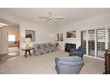 Living room with fireplace, access to patio, and view of another room at 15050 N Thompson Peak Pkwy # 1010, Scottsdale, AZ 85260