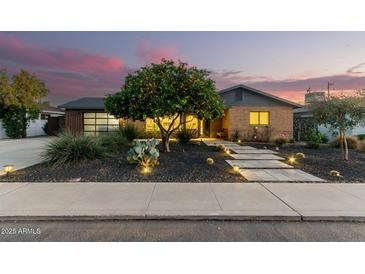 Brick home with landscaped yard, updated garage, and walkway lighting at 1837 E Minnezona Ave, Phoenix, AZ 85016