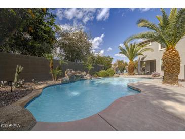 Inviting pool with waterfall feature and lush landscaping at 1908 E Hawken Pl, Chandler, AZ 85286